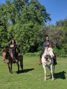 two girls riding horses in field